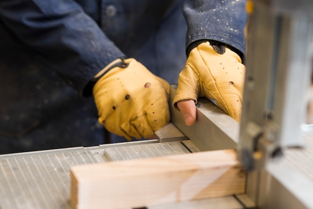 Primo piano delle mani di un carpentiere che lavorano con il blocco di legno sul banco da lavoro