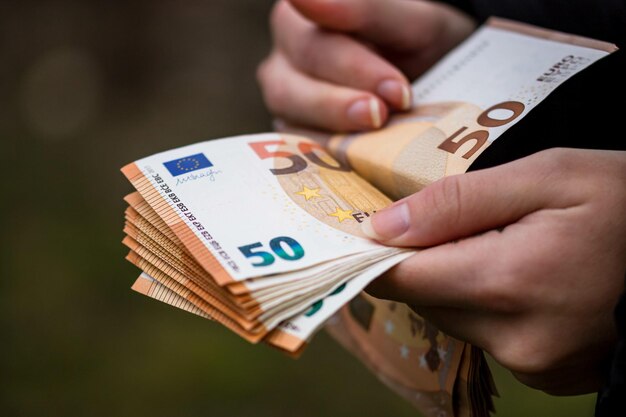 Primo piano delle mani femminili che contano le banconote in EURO l'inflazione mondiale dei soldi e il concetto di economia