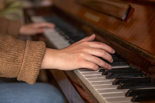 Primo piano delle mani femminili che suonano il pianoforte