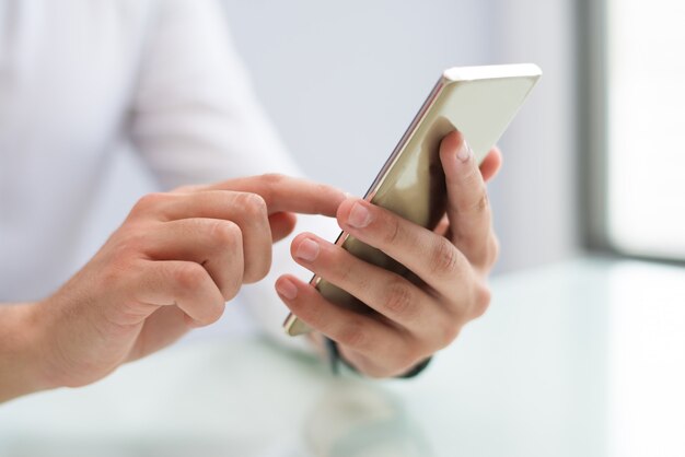 Primo piano delle mani maschile utilizzando smartphone