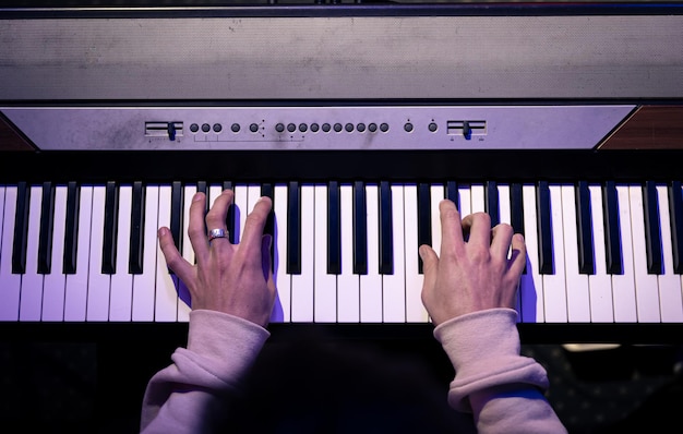 Primo piano delle mani maschili che suonano i tasti del pianoforte