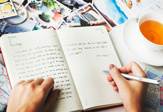 Primo piano delle mani scrivendo un diario