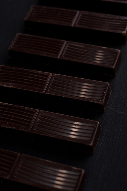 Primo piano delle mattonelle della barra di cioccolato fondente in una fila
