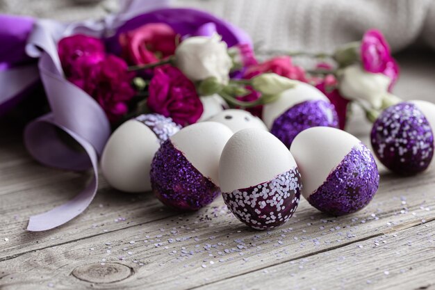 Primo piano delle uova di Pasqua decorate con scintillii viola