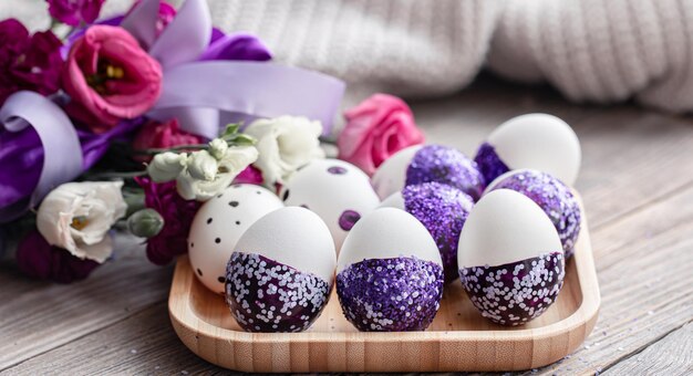 Primo piano delle uova di Pasqua decorate con scintillii viola