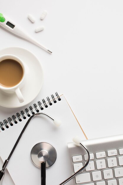 Primo piano dello scrittorio medico di sanità con la tazza di caffè su superficie bianca