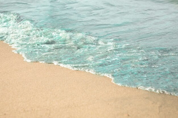 Primo piano di acqua sulla spiaggia di sabbia tropicale