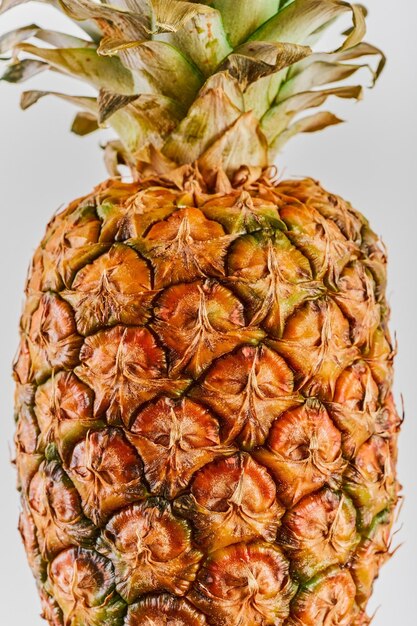 Primo piano di ananas maturo su uno sfondo bianco con copia Frutta tropicale matura e succosa Prospetto di consegna o cornice verticale idea volantino