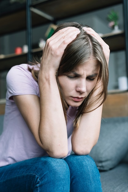 Primo piano di bella giovane donna che soffre di mal di testa