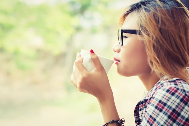 Primo piano di bere il caffè ragazza con sfondo sfocato