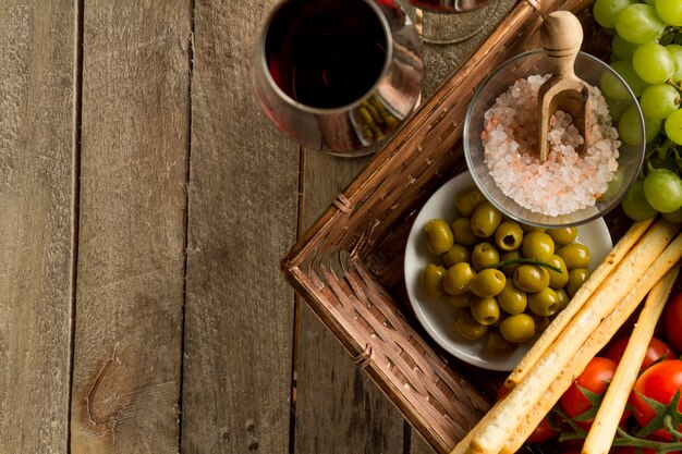 Primo piano di bicchieri di vino accanto a un cesto di vimini con prodotti