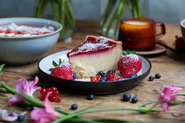 Primo piano di cheesecake con gelatina decorata con fragole e frutti di bosco and