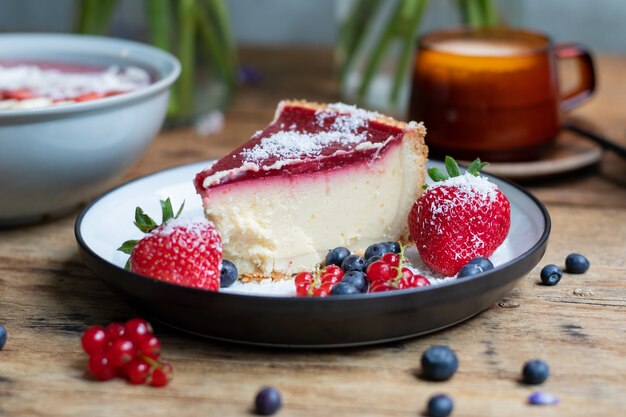 Primo piano di cheesecake con gelatina decorata con fragole e frutti di bosco