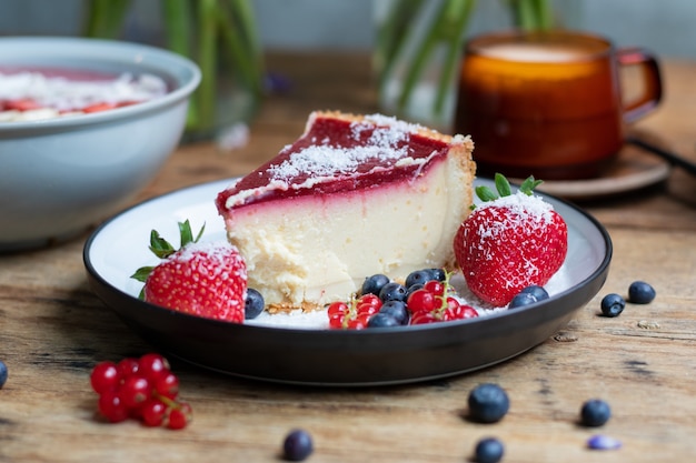 Primo piano di cheesecake con gelatina decorata con fragole e frutti di bosco