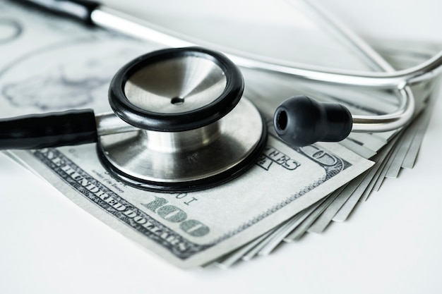 Primo piano di contanti e un concetto di assistenza sanitaria e spese stetoscopio