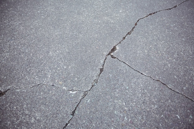 Primo piano di cracking strada asfaltata sfondo