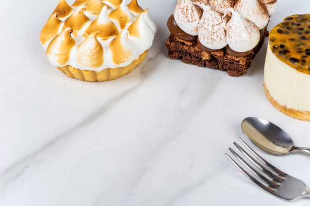 Primo piano di deliziosi mini cioccolato, torta al limone e torta al frutto della passione. Concetto di cuoco.