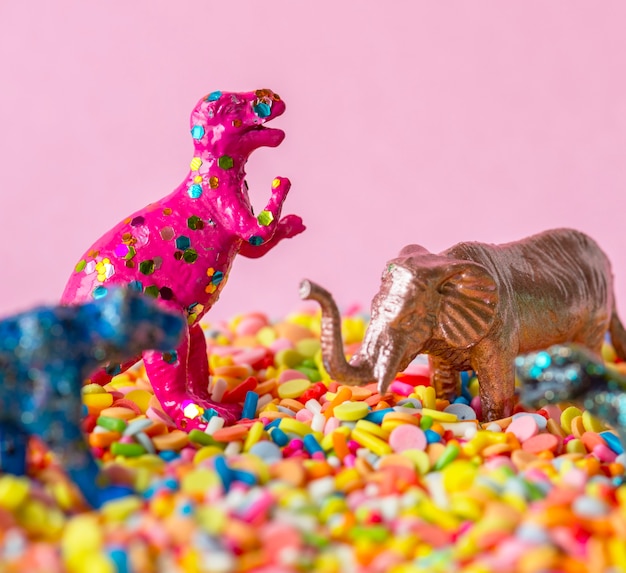 Primo piano di dinosauri e giocattoli figura animale su caramelle dolci sprinkles