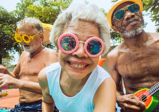 Primo piano di diversi adulti senior seduti in piscina godendo l&#39;estate insieme