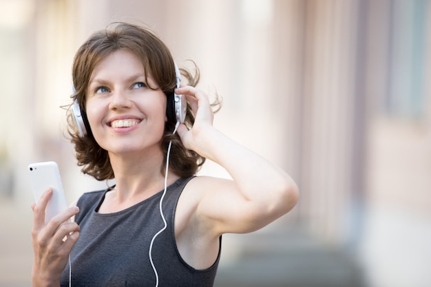 Primo piano di donna allegra ascoltare la musica