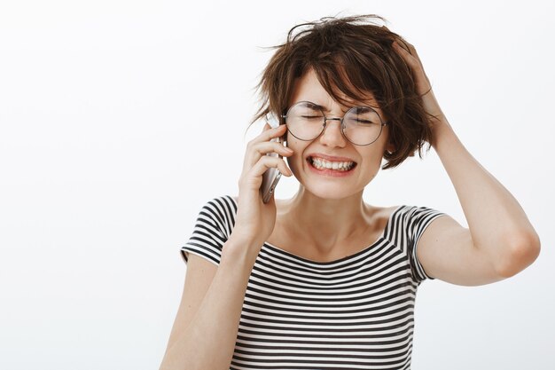 Primo piano di donna turbata e sconvolta sente cattive notizie sul telefono, sentendosi infastidita