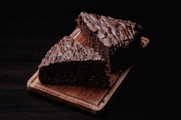 Primo piano di due pezzi di gustosa torta al cioccolato su una tavola di legno