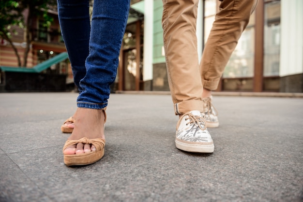 Primo piano di gambe di coppia in keds camminando per strada.