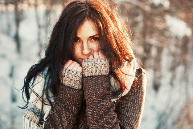 Primo piano di giovane donna che copre la bocca con i pugni