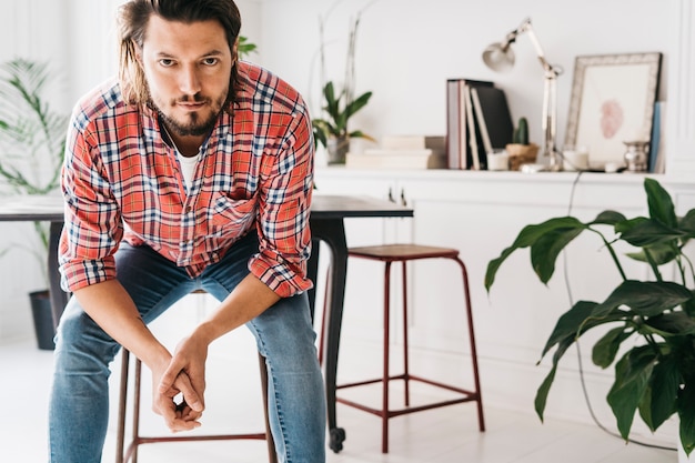 Primo piano di giovane uomo serio che guarda l&#39;obbiettivo