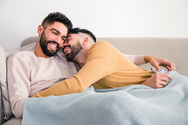 Primo piano di giovani coppie gay romantiche che si trovano sul sofà