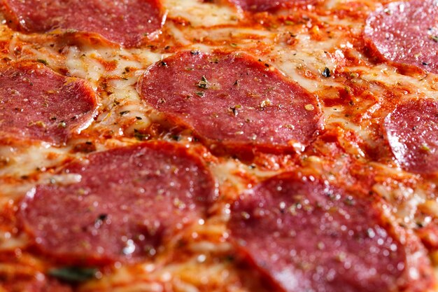 Primo piano di gustosa pizza salame appetitoso con formaggio e spezie.