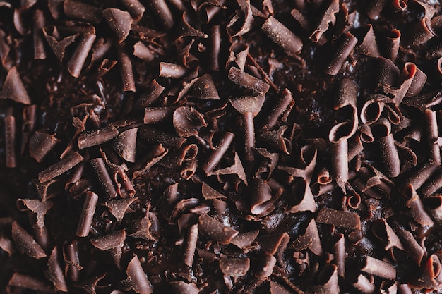 Primo piano di gustosa torta al cioccolato con pezzi di cioccolato su teglia. Avvicinamento.