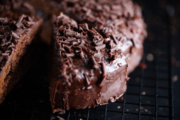Primo piano di gustosa torta al cioccolato con pezzi di cioccolato su teglia.