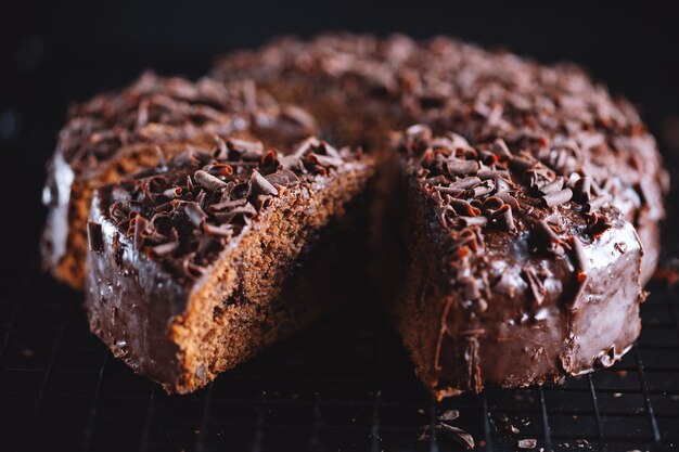 Primo piano di gustosa torta al cioccolato con pezzi di cioccolato su teglia.