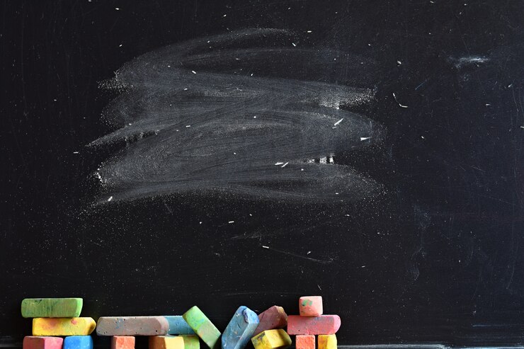 Primo piano di lavagna con pezzi di gesso colorato