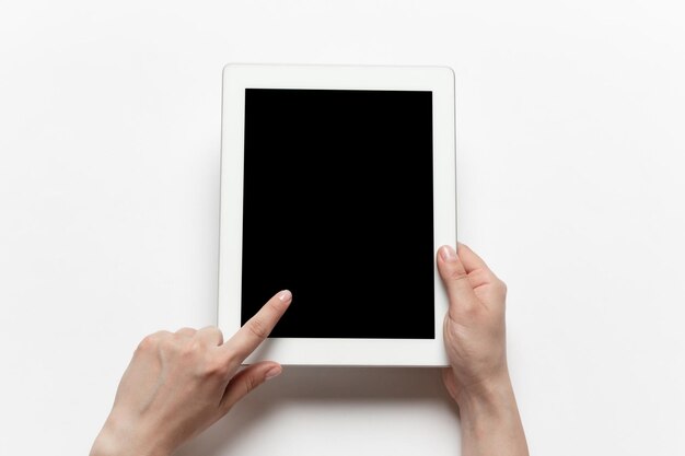 Primo piano di mani umane utilizzando tablet con schermo nero vuoto