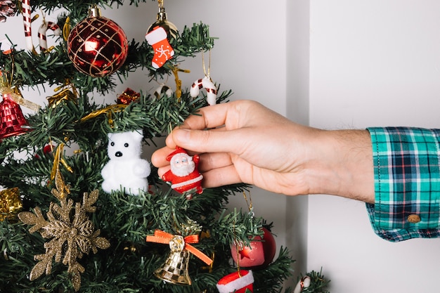 Primo piano di mano decorare albero di natale