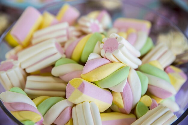 Primo piano di marshmallow colorati in una ciotola sotto le luci