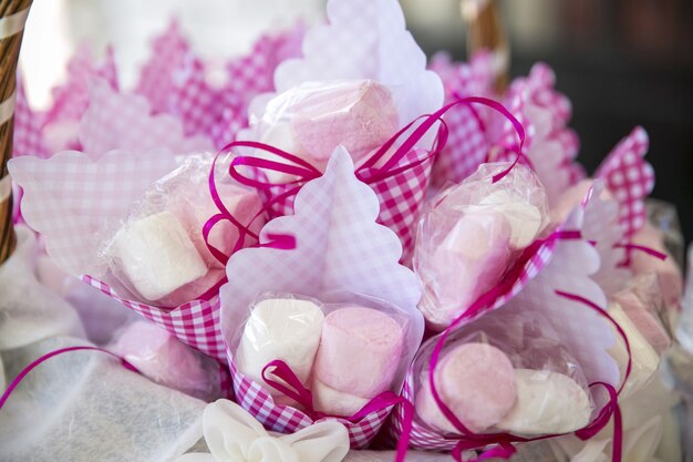 Primo piano di marshmallow in confezioni sotto le luci con uno sfondo sfocato