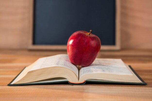 Primo piano di mela rossa con il libro aperto