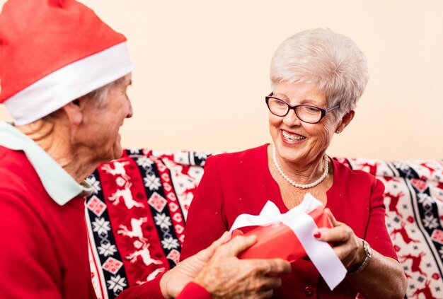 Primo piano di nonni dando regali di Natale