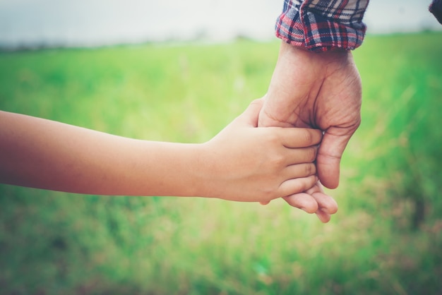 Primo piano di padre che tiene la sua mano figlia, così dolce, ti famiglia