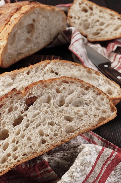 Primo piano di pezzi di pane rustico su un asciugamano di cotone Disposizione del pane integrale fatto in casa sul telaio verticale del tavolo