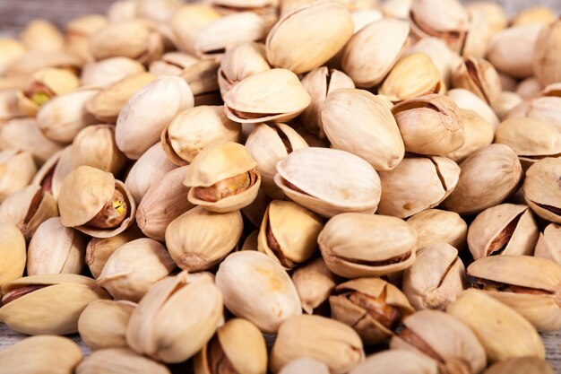 Primo piano di pistacchi su sfondo di legno in studio fotografico. Snack sani e deliziosi