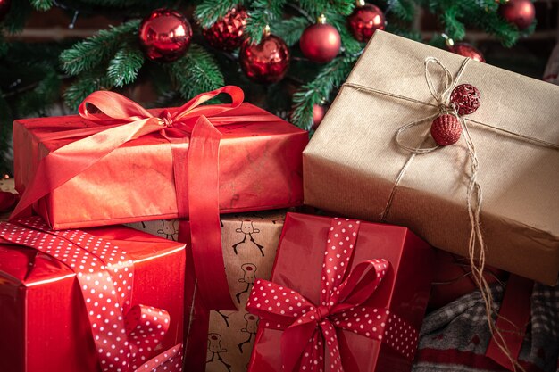 Primo piano di scatole regalo rosse vicino all'albero di Natale