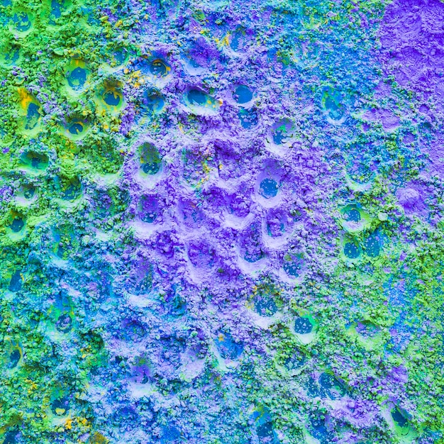 Primo piano di sfondo di polvere di colore viola e verde holi