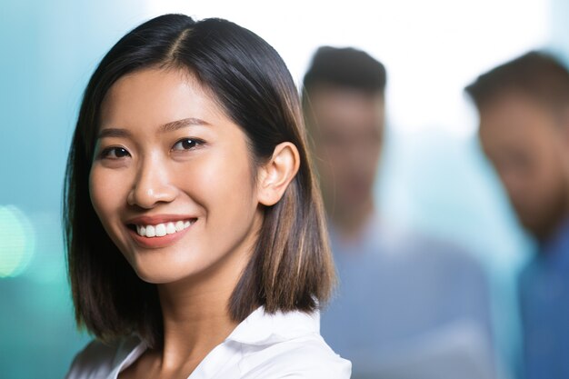 Primo piano di sorridente abbastanza giovane donna asiatica