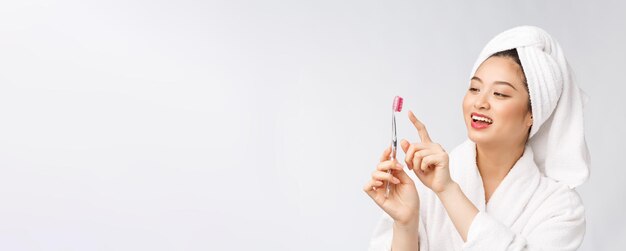 Primo piano di sorriso donna spazzola denti grande per la salute dentale concetto di cura isolato su sfondo bianco asiatico