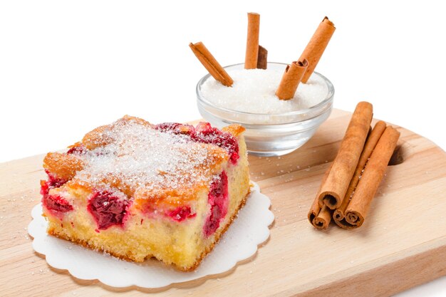 Primo piano di torta di amarene con zucchero e bastoncini di cannella