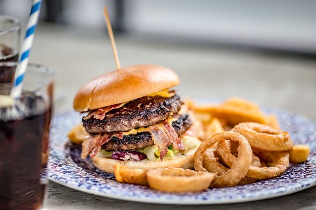 Primo piano di un appetitoso hamburger con anelli di cipolla